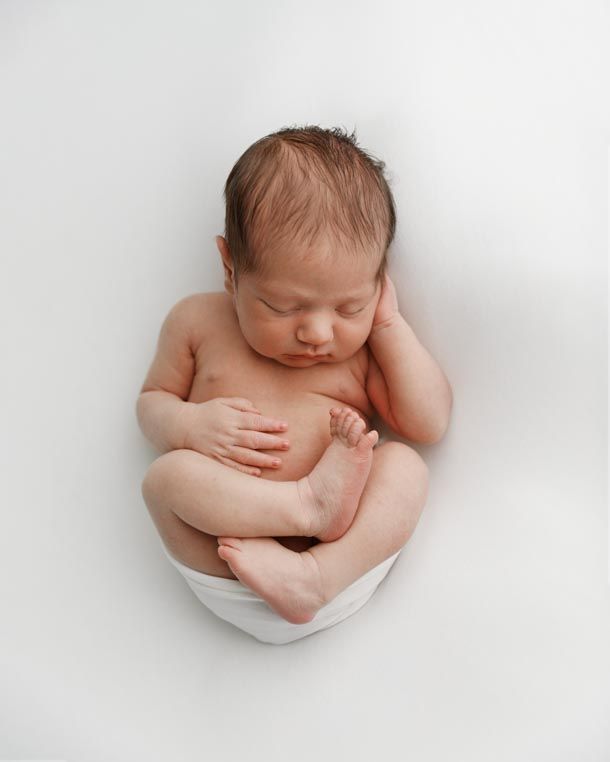 Nyf&oslash;dtfotografering - Baby sover p&aring; rygg p&aring; hvitt teppe under fotografering