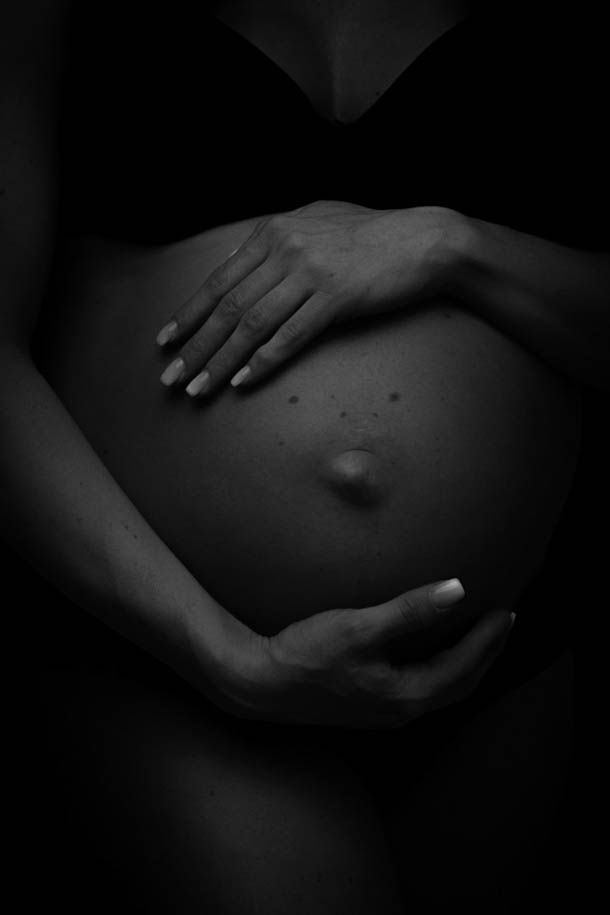 Gravidfotografering - n&aelig;rbilde av hender som holder rundt mage