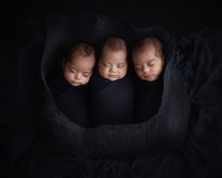 Nyf&oslash;dtfotografering - trillinger ligger sammen surret inn i bl&aring; tepper med bl&aring; ullfilt rundt alle tre